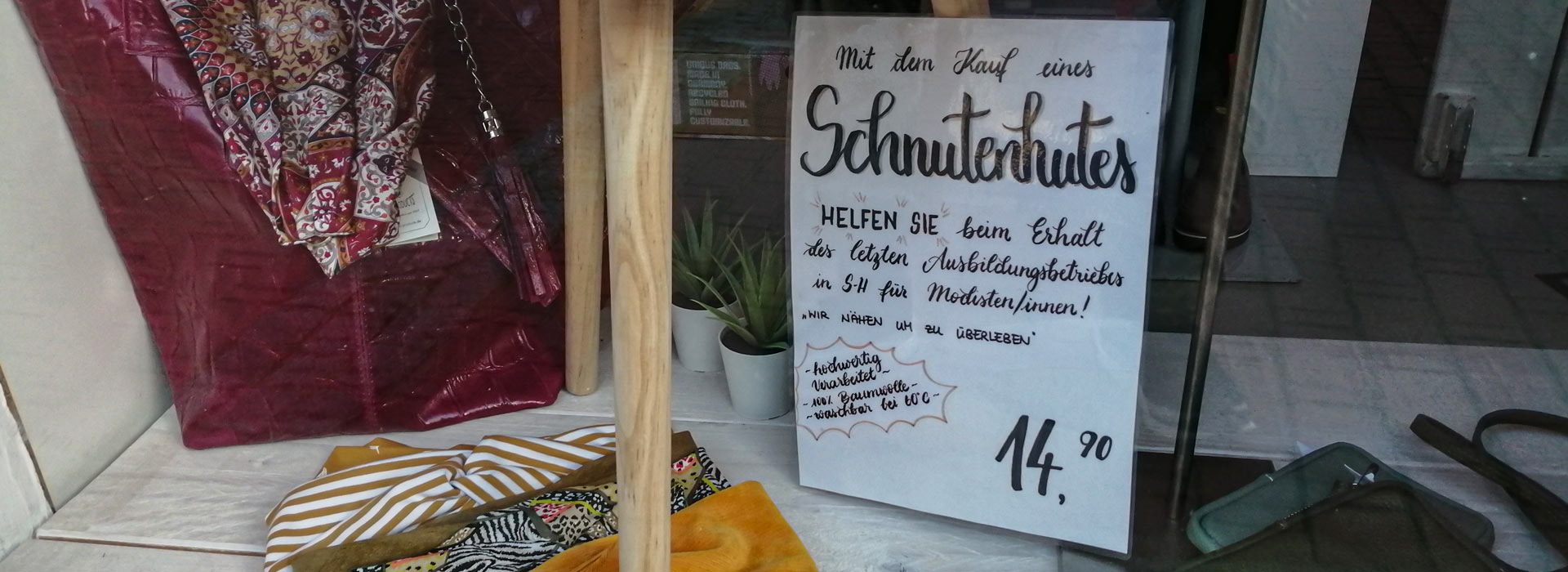 Werbeschild im Schaufenster mit einem Aufruf zur Hilfe für einen Ausbildungsbetrieb.
